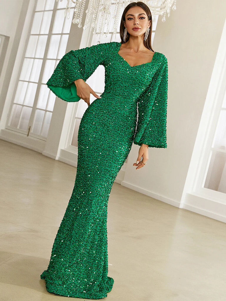 This stunning Emerald Green sequin gown features a sweetheart neckline, dramatic bell sleeves, and a form-fitting mermaid silhouette, perfect for a glamorous evening event.