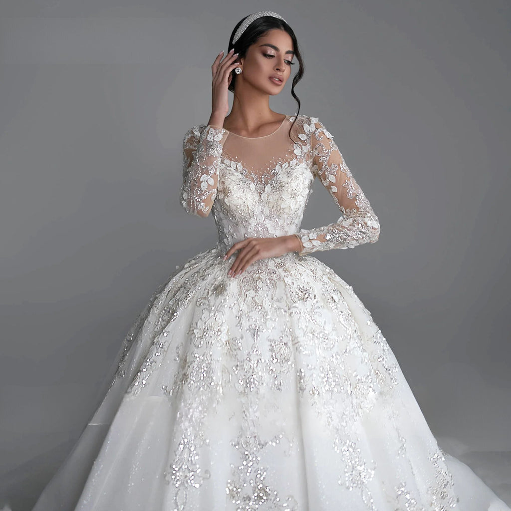 Exquisite long sleeve ball gown wedding dress with sequined beading and royal train, available in champagne, white, beige, ivory, and pink.