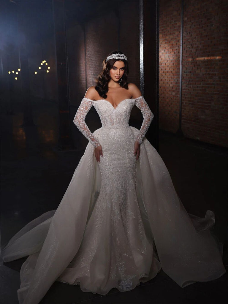 Luxurious off-shoulder mermaid bridal gown with beading and lace appliques, available in white and champagne.