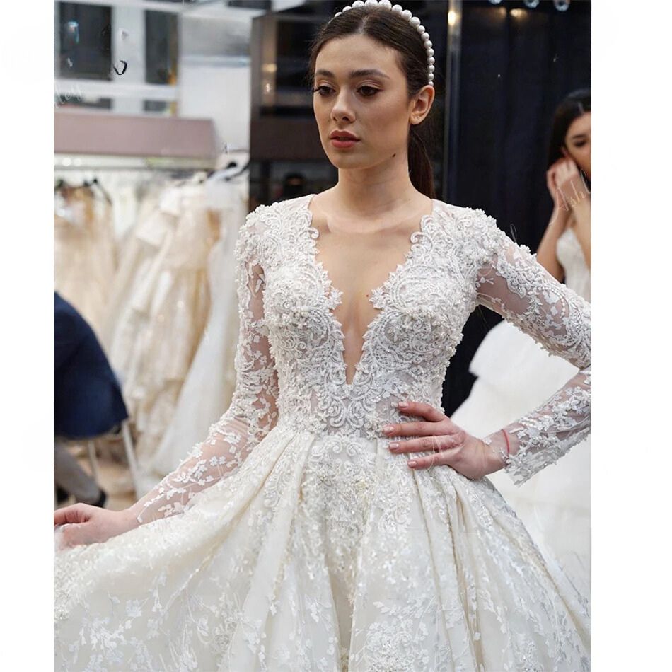 Elegant long sleeve beaded appliques V-neck princess wedding dress, available in champagne, ivory, beige, and white.