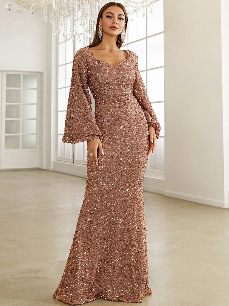 This stunning Pink sequin gown features a sweetheart neckline, dramatic bell sleeves, and a form-fitting mermaid silhouette, perfect for a glamorous evening event.