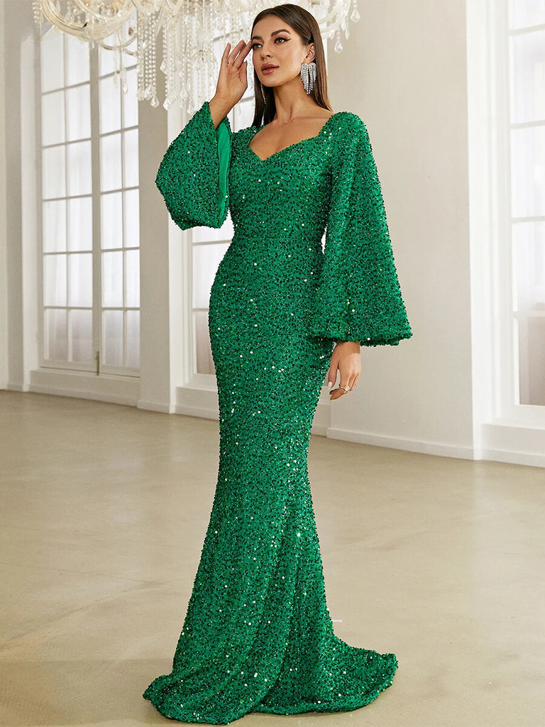 This stunning emerald green sequin gown features a sweetheart neckline, dramatic bell sleeves, and a form-fitting mermaid silhouette, perfect for a glamorous evening event.