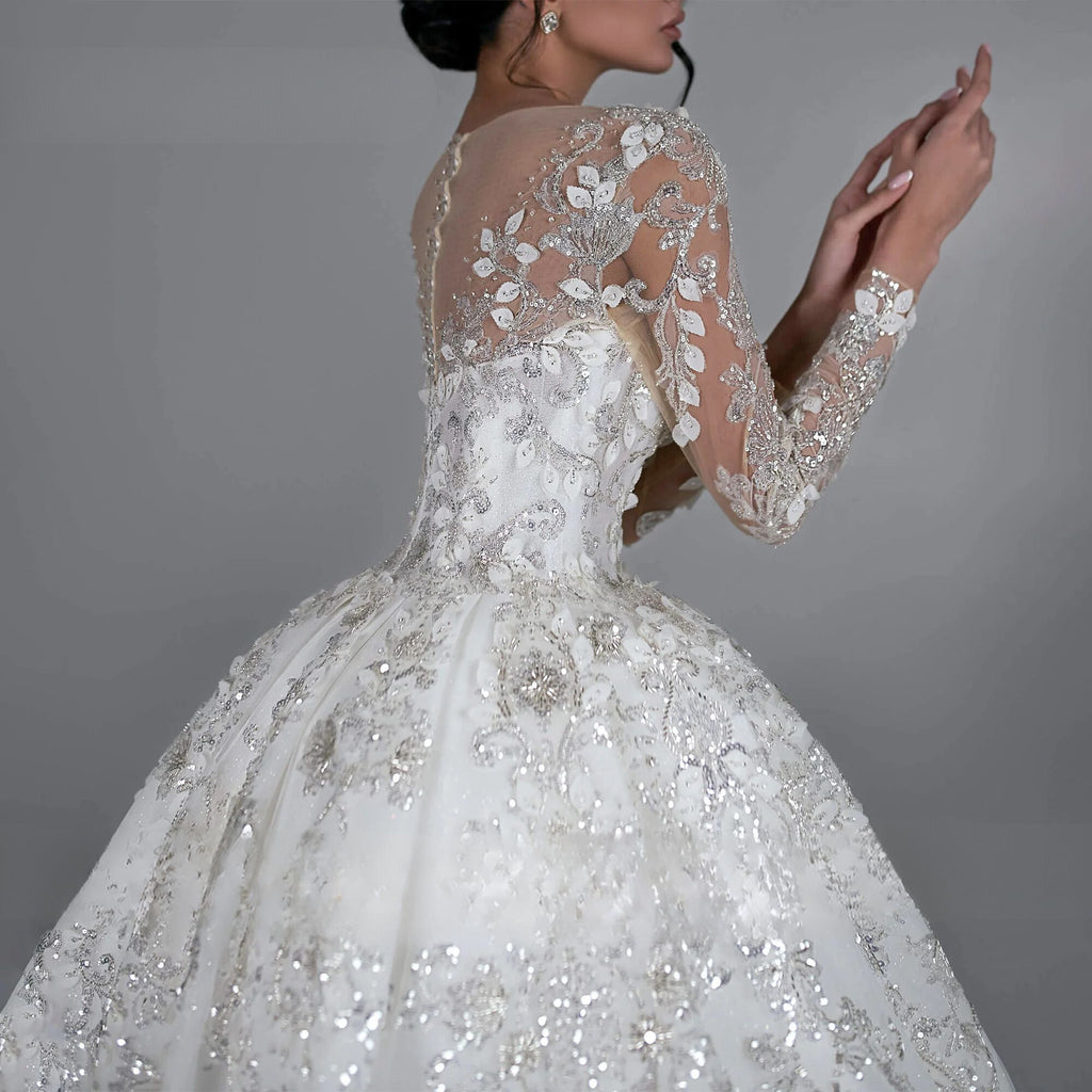 Exquisite long sleeve ball gown wedding dress with sequined beading and royal train, available in champagne, white, beige, ivory, and pink.