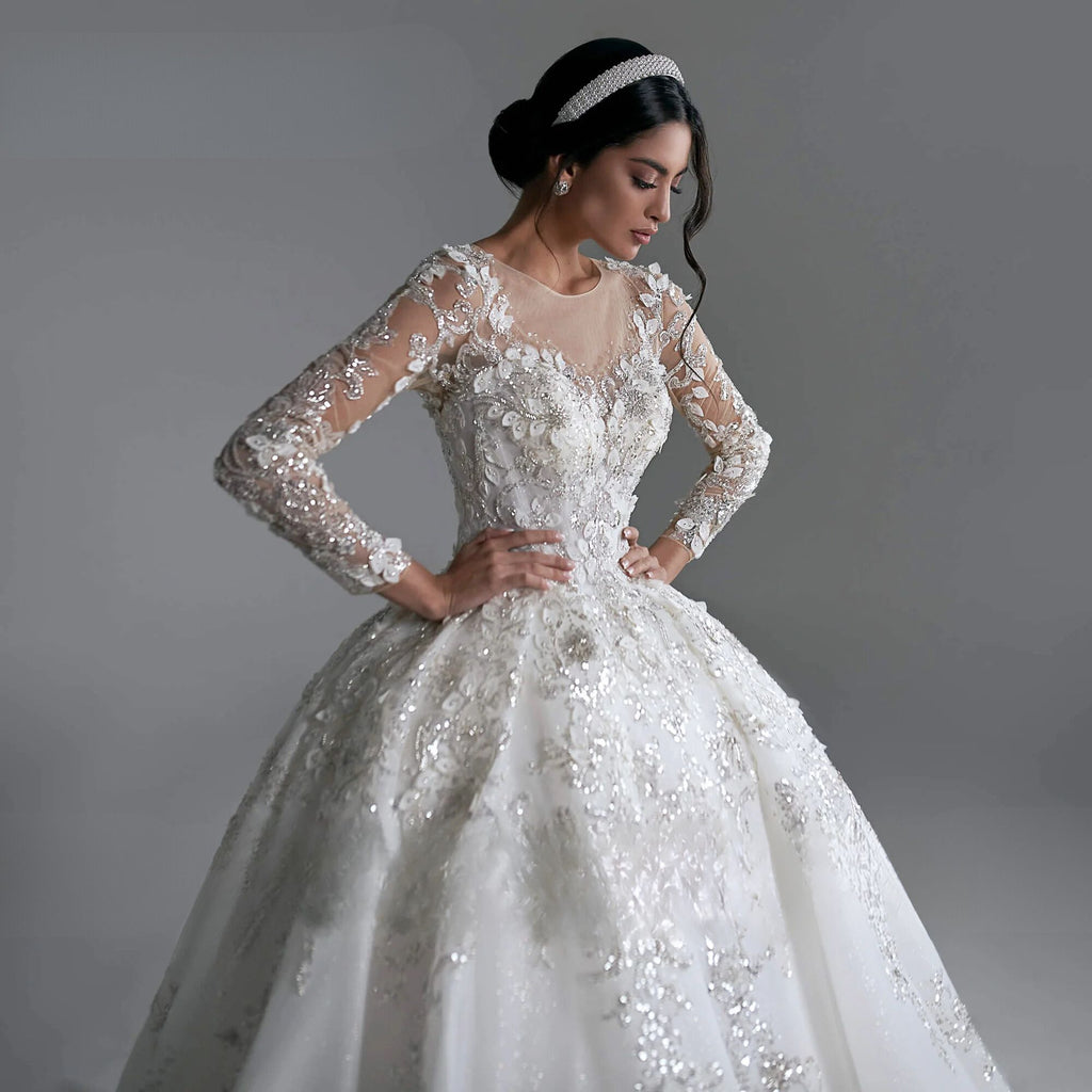 Exquisite long sleeve ball gown wedding dress with sequined beading and royal train, available in champagne, white, beige, ivory, and pink.