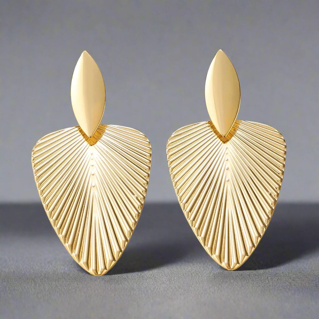 Elegant gold-tone earrings featuring a textured leaf design, combining modern sophistication with a nature-inspired motif, perfect for adding a stylish touch to any outfit.