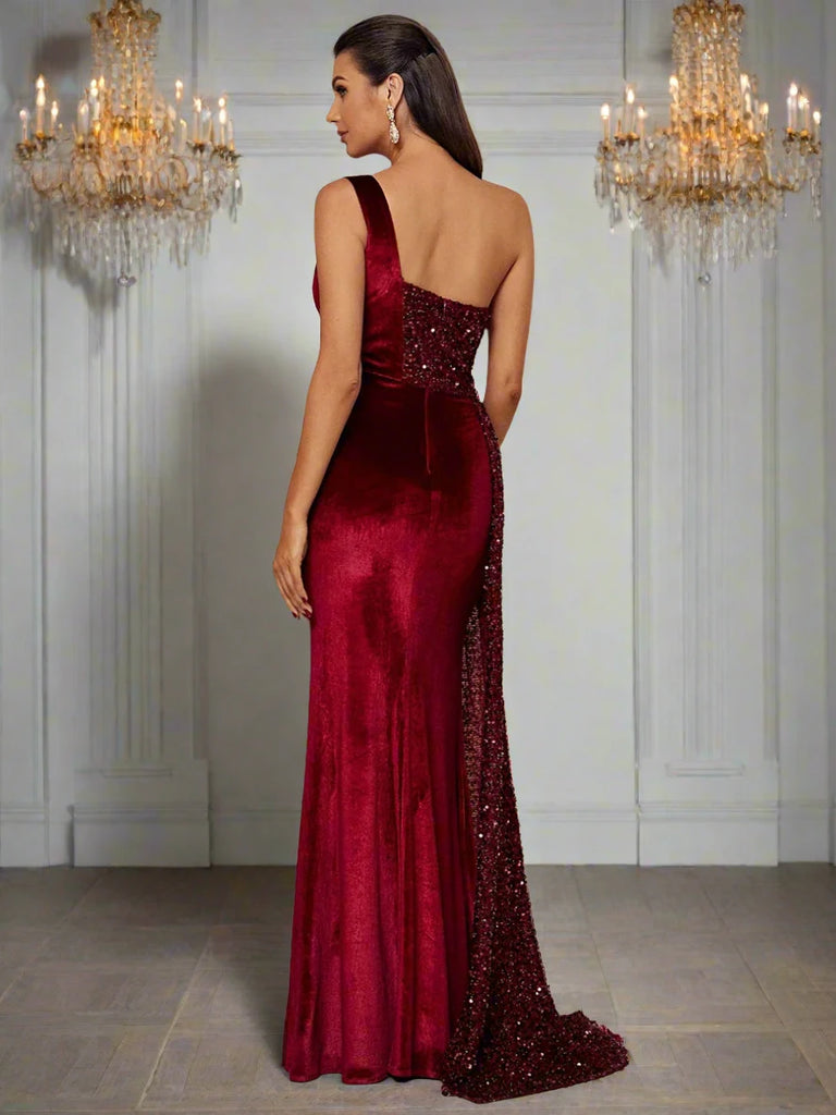 Velvet sequin prom dress with a one-shoulder asymmetrical neckline, draped high split, and floor-length design.