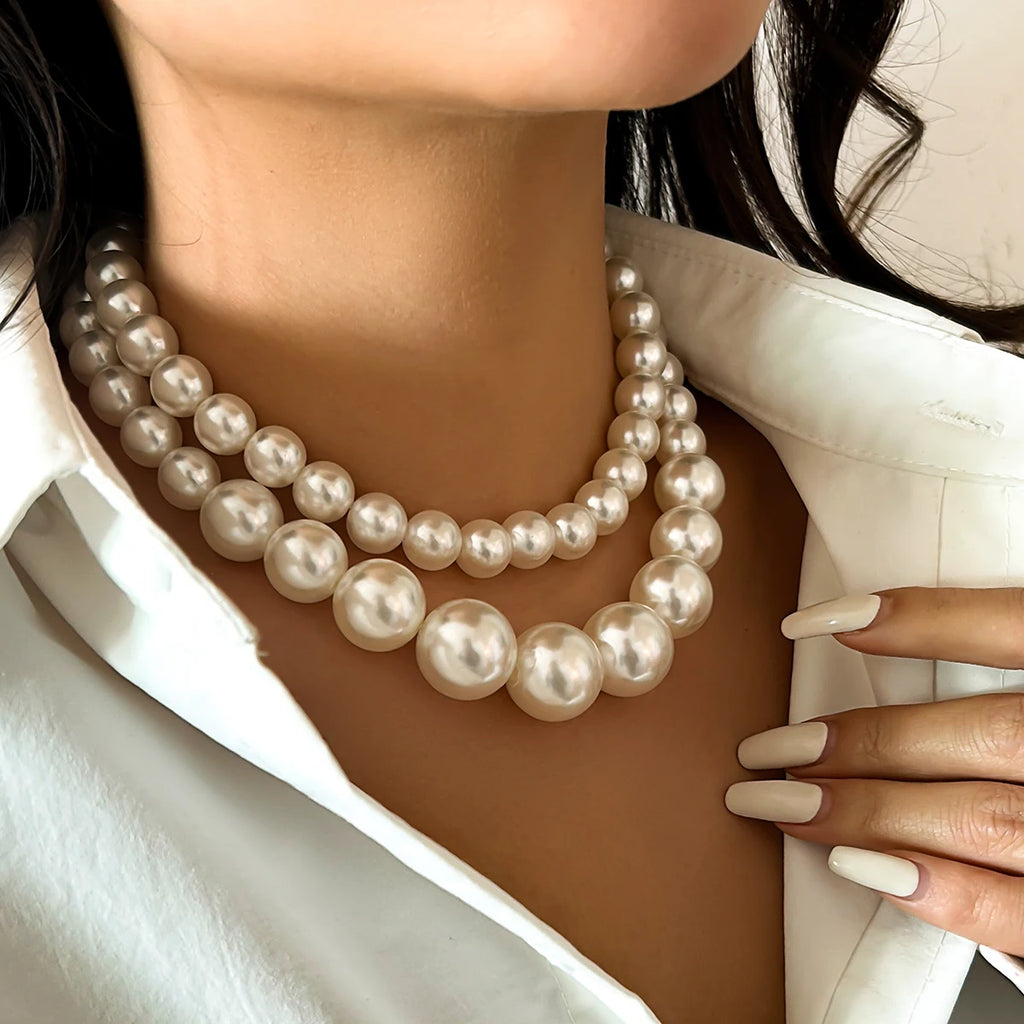 A luxurious double-strand pearl necklace featuring large, lustrous pearls in a graduated design, adding a touch of timeless elegance and sophistication to any outfit.