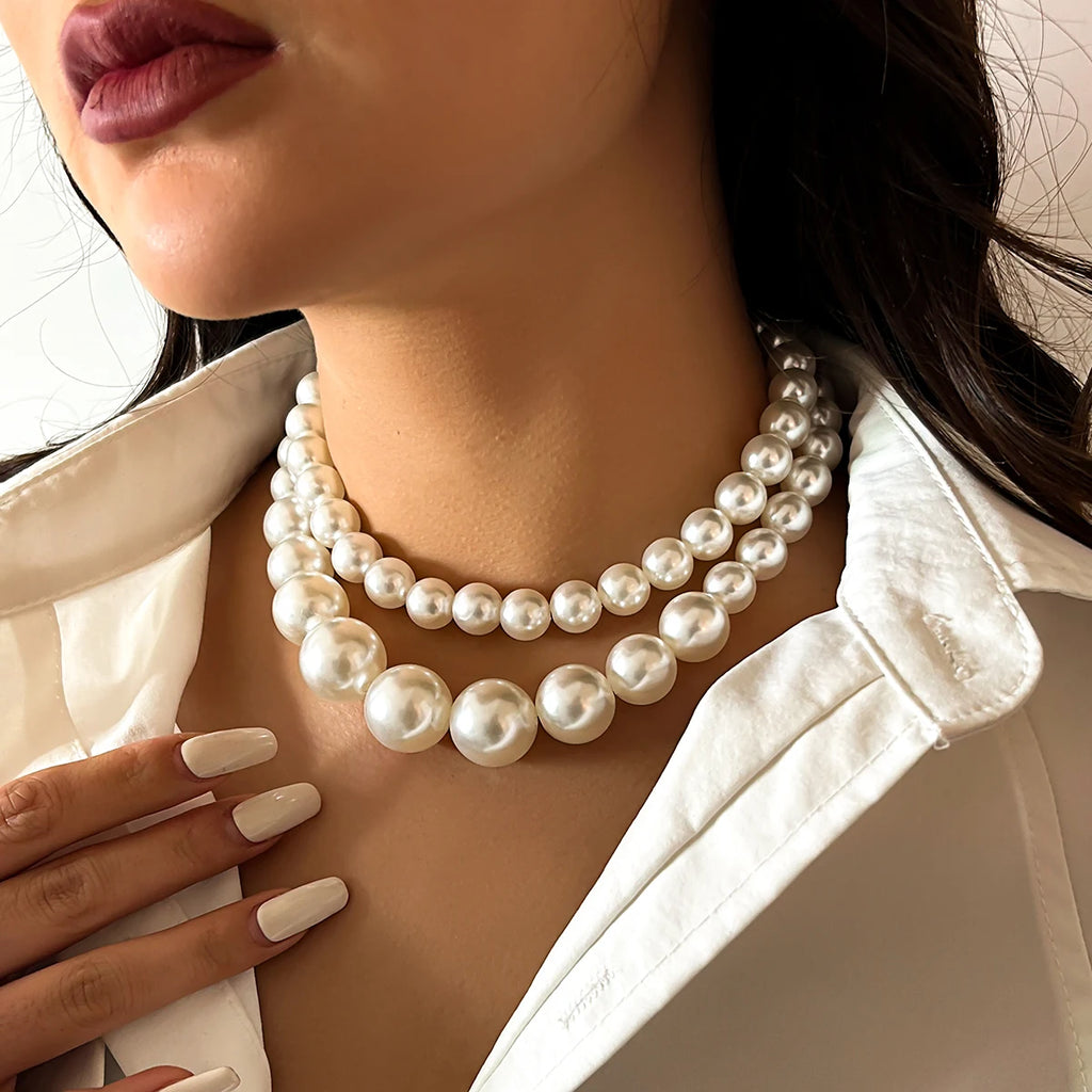 A luxurious double-strand pearl necklace featuring large, lustrous pearls in a graduated design, adding a touch of timeless elegance and sophistication to any outfit.