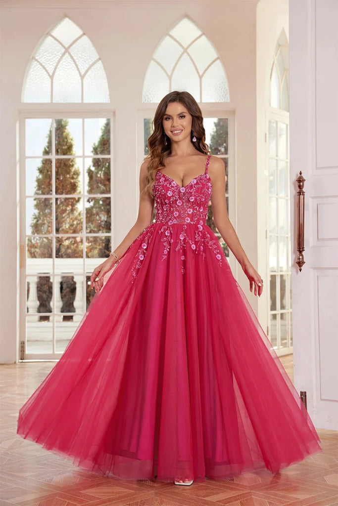 An elegant pink  tulle ball gown features a fitted bodice adorned with delicate floral appliqués and thin straps. The full, flowing skirt adds a fairytale touch, perfect for proms, formal events, or weddings.