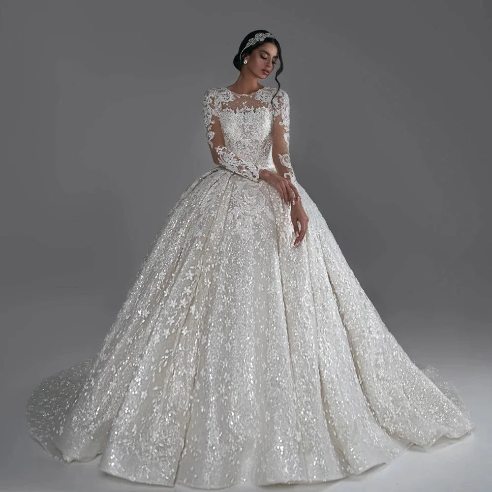 Luxury royal ball gown wedding dress with lace appliques and long sleeves, available in ivory, pink, white, and champagne.