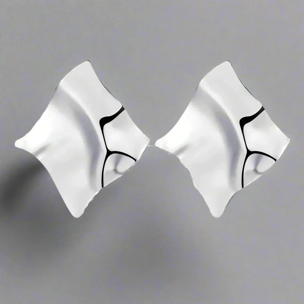 Modern Silver-tone earrings with an abstract, flowing design, featuring smooth, sculptural curves that create a bold and artistic statement.







