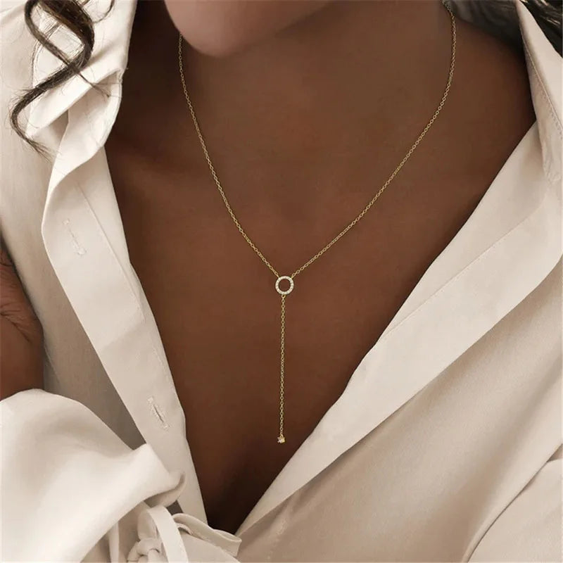 A delicate layered necklace featuring two slim silver-tone chains, each adorned with a minimalist circle pendant, with the lower chain extending into a Y-shaped drop for an elegant and refined look.