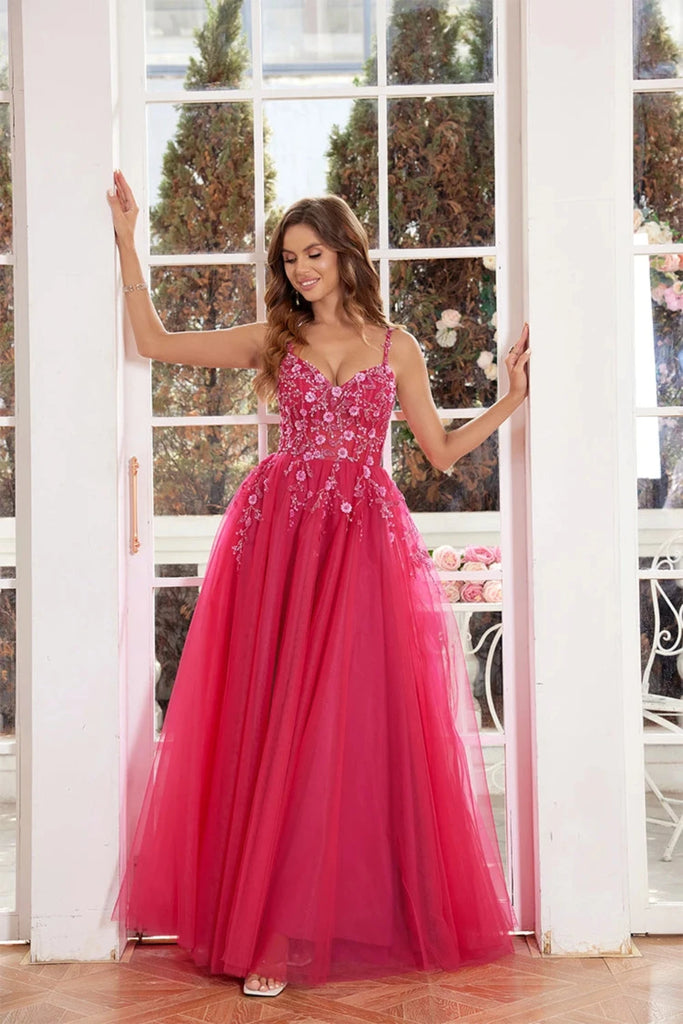 Elegant pink tulle ball gown featuring a fitted bodice adorned with delicate floral appliqués and thin straps. The full, flowing skirt adds a fairytale touch, making it perfect for proms, formal events, or weddings.