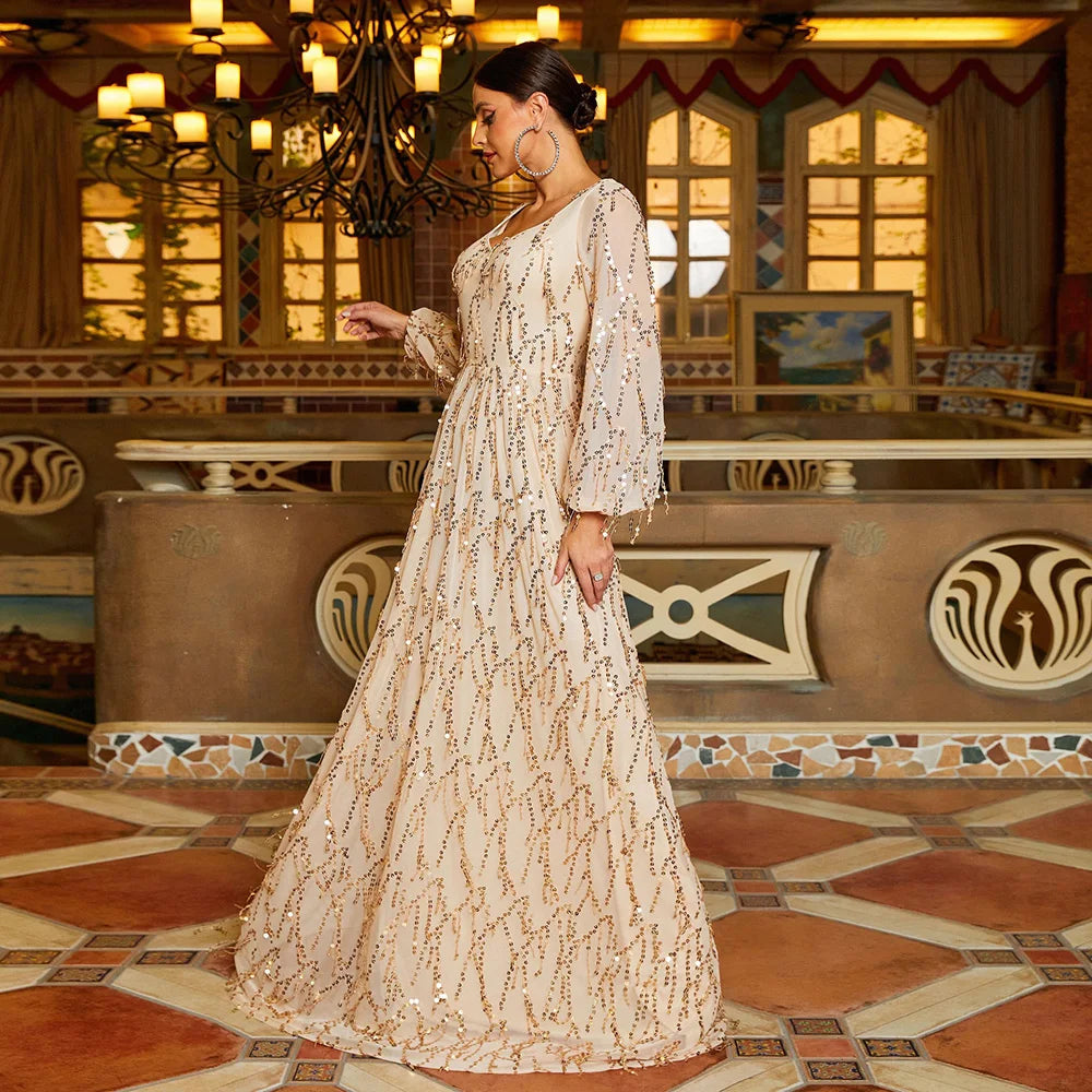 Champagne-colored prom gown with sequins, tassel details, and long lantern sleeves for an elegant evening look.