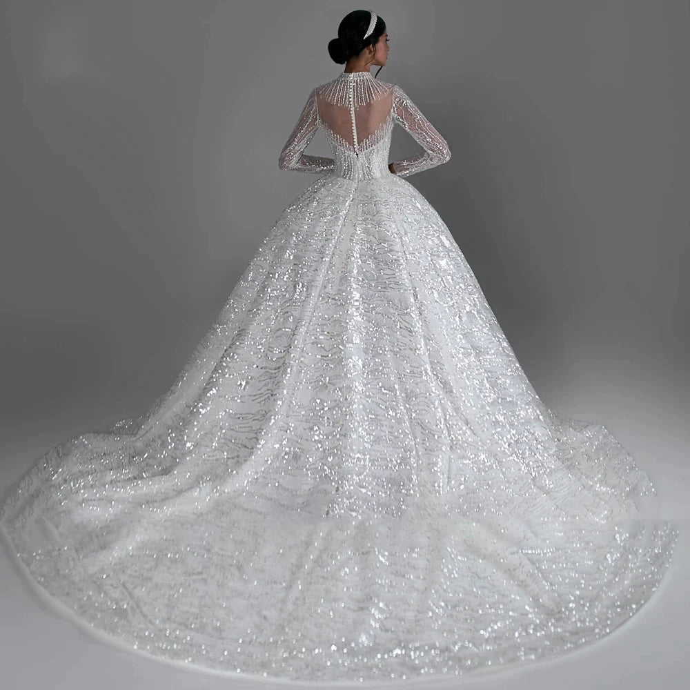 High V-neck long sleeve ball gown wedding dress with lace appliques and beaded details, available in ivory and white.