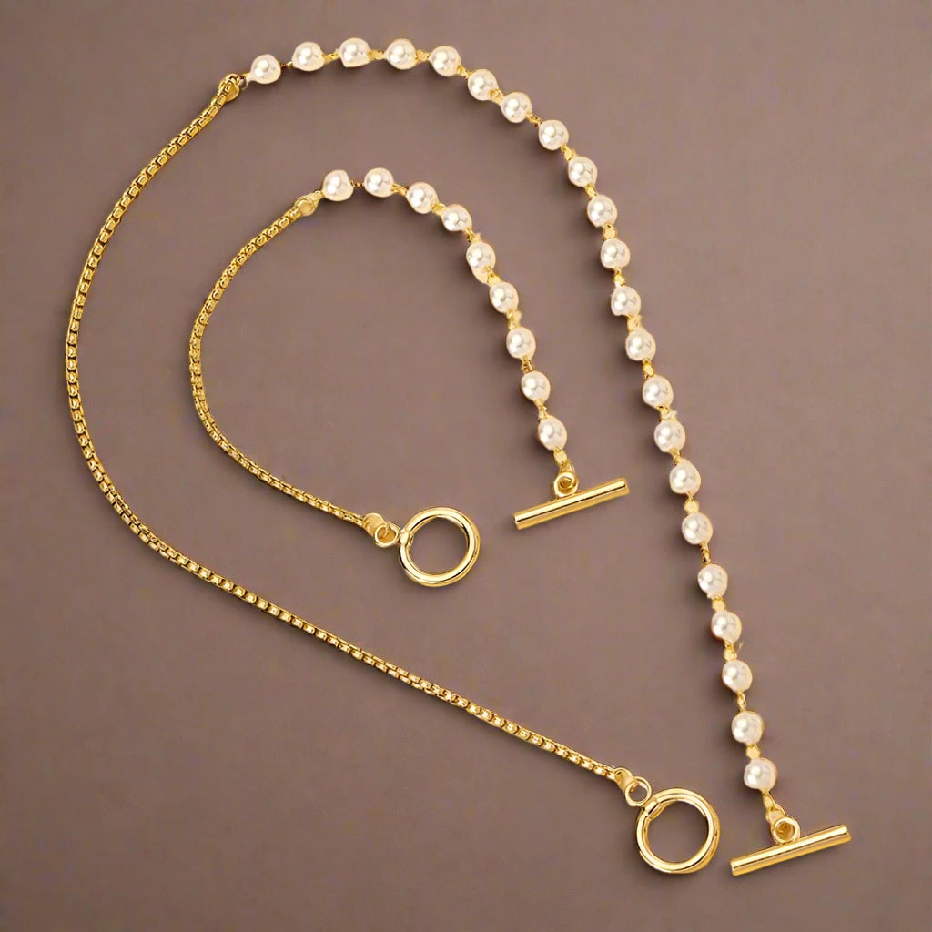 stylish jewelry set featuring a necklace and bracelet, combining classic pearls with a modern gold-tone chain and toggle clasp, offering a chic and elegant accessory perfect for any occasion.