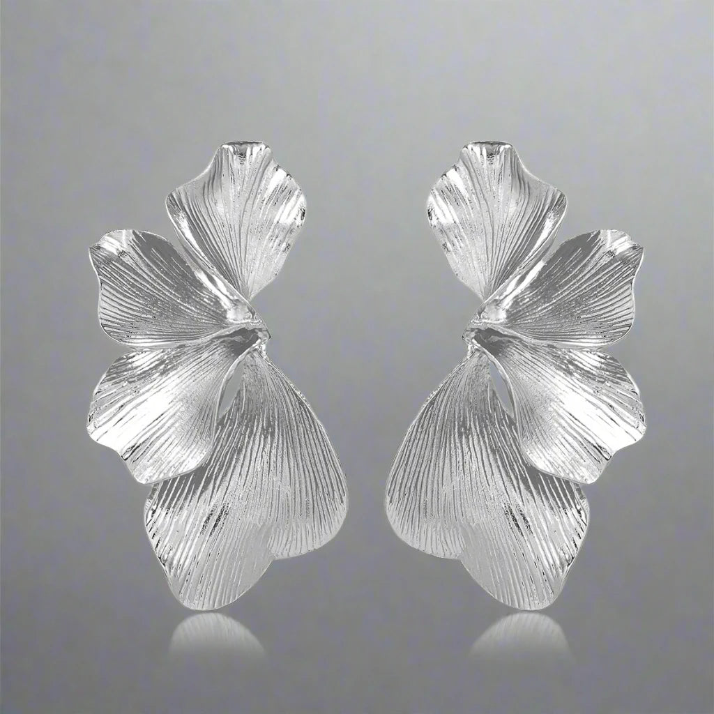 A pair of Silver delicate floral leaf stud earrings, intricately designed with a nature-inspired motif, perfect for adding a touch of elegance and charm to any outfit.
