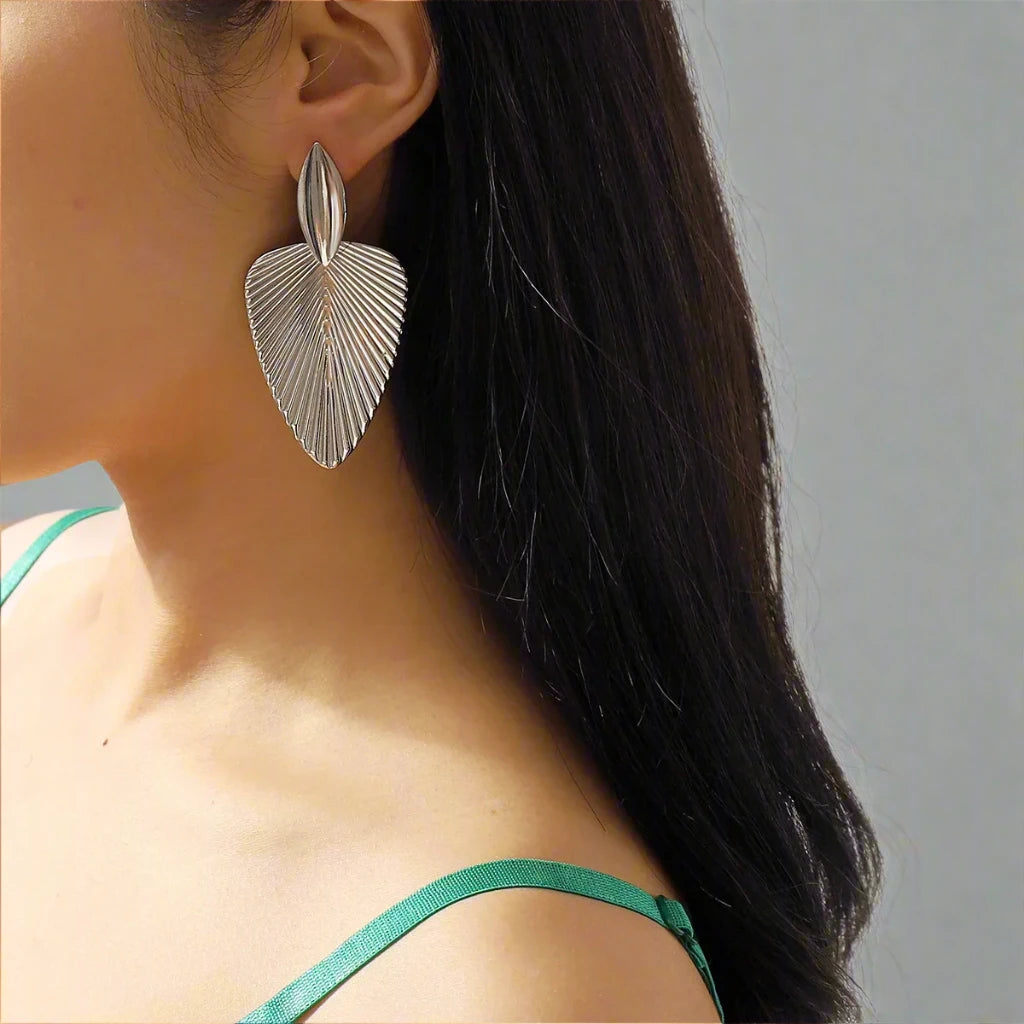 Elegant Silver-tone earrings featuring a textured leaf design, combining modern sophistication with a nature-inspired motif, perfect for adding a stylish touch to any outfit.