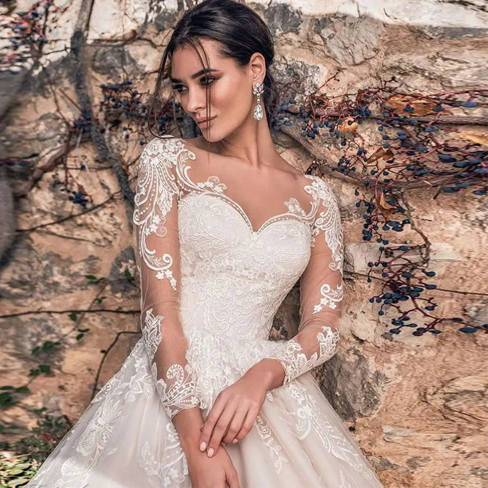 Gorgeous lace long sleeve wedding dress with illusion back and tulle A-line silhouette, available in ivory and white.