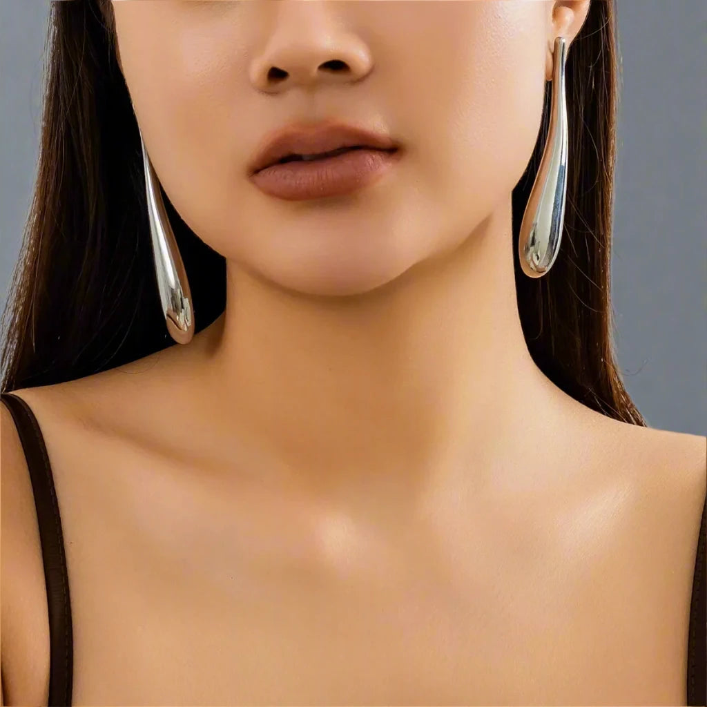 A sleek and modern Silver-tone earring featuring an elongated teardrop design, adding a touch of sophistication and elegance to any look.