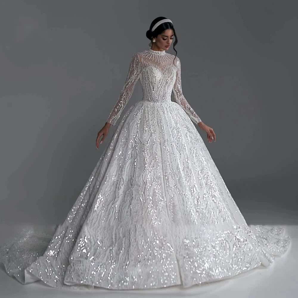 High V-neck long sleeve ball gown wedding dress with lace appliques and beaded details, available in ivory and white.