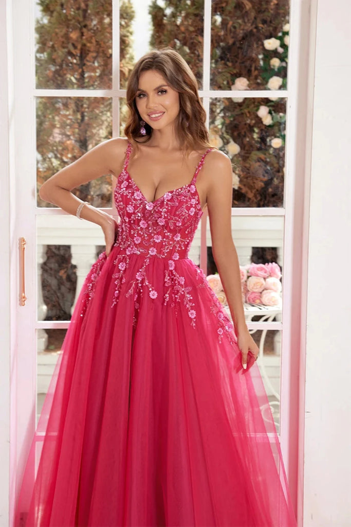 An elegant pink  tulle ball gown features a fitted bodice adorned with delicate floral appliqués and thin straps. The full, flowing skirt adds a fairytale touch, perfect for proms, formal events, or weddings.