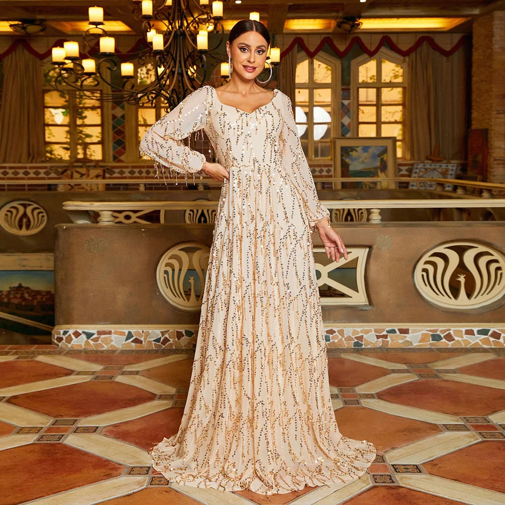 Champagne-colored prom gown with sequins, tassel details, and long lantern sleeves for an elegant evening look.