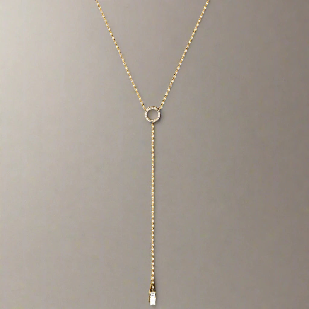 A delicate layered necklace featuring two slim gold-tone chains, each adorned with a minimalist circle pendant, with the lower chain extending into a Y-shaped drop for an elegant and refined look.