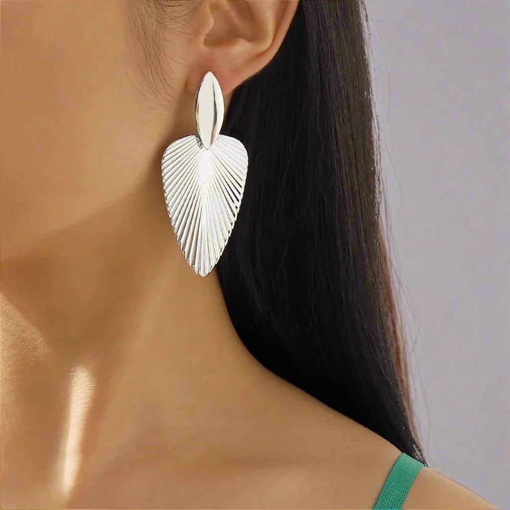 Elegant Silver-tone earrings featuring a textured leaf design, combining modern sophistication with a nature-inspired motif, perfect for adding a stylish touch to any outfit.