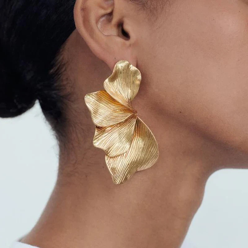 A pair of Gold delicate floral leaf stud earrings, intricately designed with a nature-inspired motif, perfect for adding a touch of elegance and charm to any outfit.
