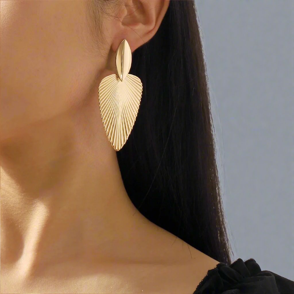 Elegant gold-tone earrings featuring a textured leaf design, combining modern sophistication with a nature-inspired motif, perfect for adding a stylish touch to any outfit.