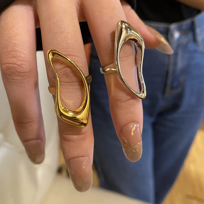 A pair of sculptural, open-design rings in polished gold and silver tones, showcasing a bold and modern aesthetic contemporary look.